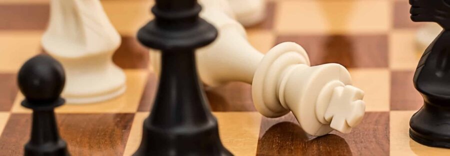 Peça de xadrez caída em um tabuleiro representando executivo demitido. (Imagem: Pexels)