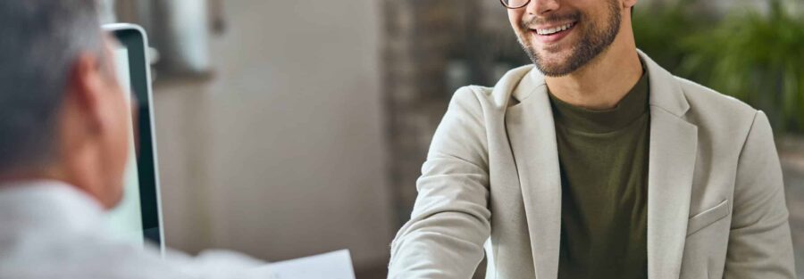 Homen feliz cumprimenta consultor que aplica um processo de outplacement de alta qualidade (Imagem: Freepik)