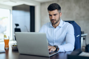 Imagem de homem no computador para ilustrar texto sobre recolocação de executivos.