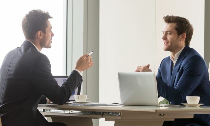 Dois profissionais em entrevista para a recolocação de executivos.