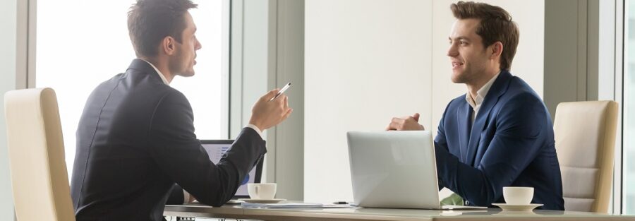 Dois profissionais em entrevista para a recolocação de executivos.