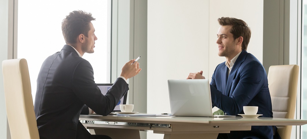 Dois profissionais em entrevista para a recolocação de executivos.